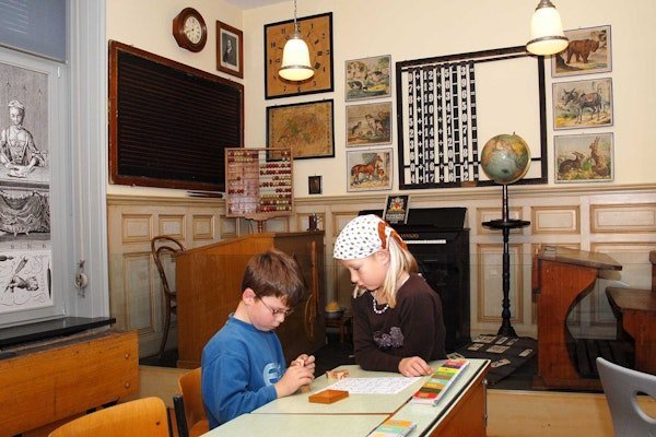 Zwei Kinder spielen im Schulzimmer im Kindermuseum Baden
