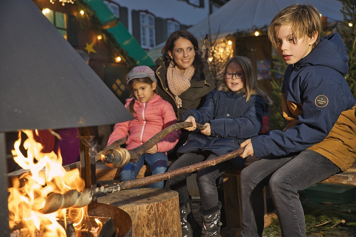 Ein offenes Feuer beim Basler Weihnachtsmarkt lädt die Familie ein zum Aufwärmen und Schlangenbrot machen.