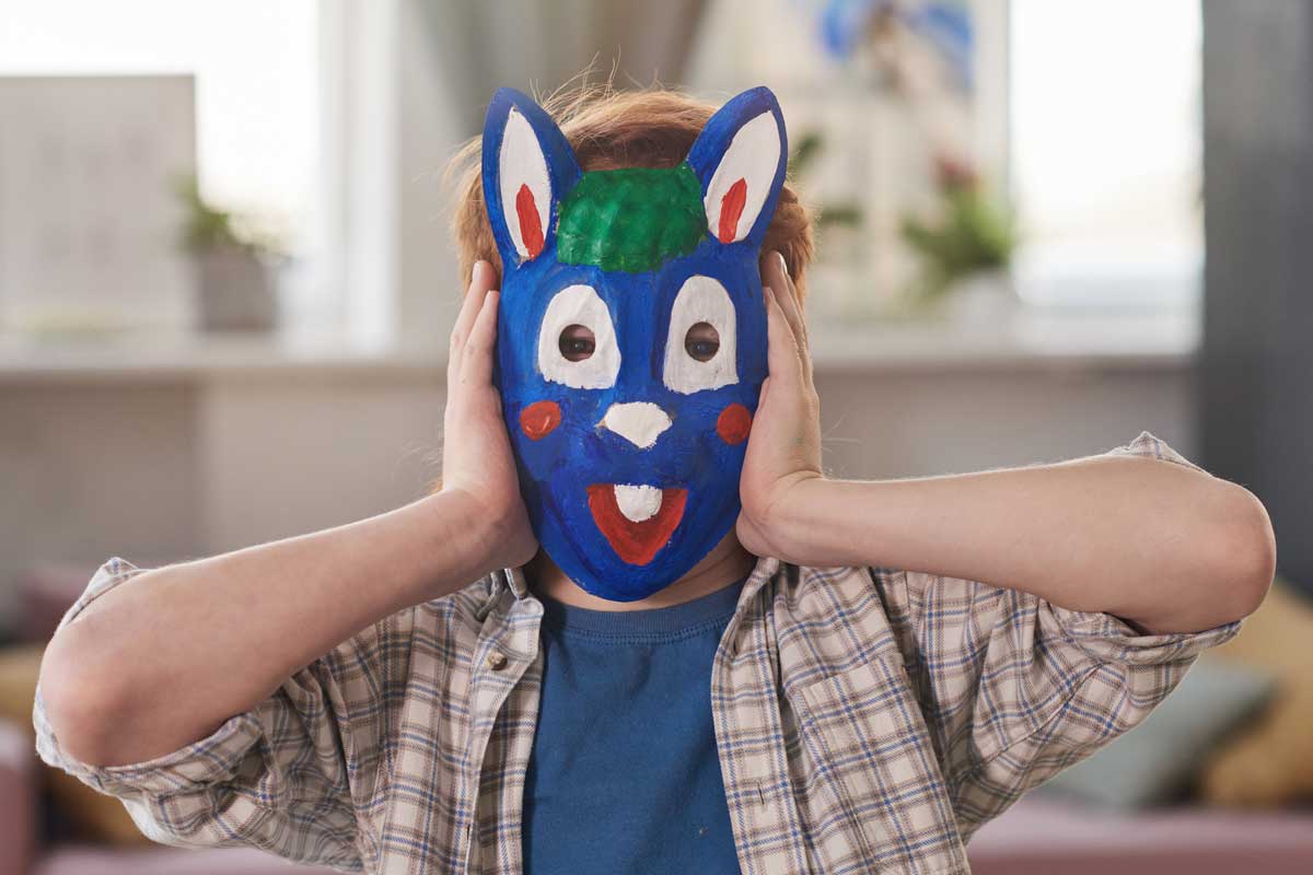 Ein Kind mit einer selbstgebastelten Maske für die Fasnacht.