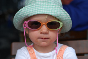 Wandern mit Kindern: Ein Kind und auch Erwachsene müssen sich mit Sonnenhut und Sonnenbrille vor der Sonne schützen.