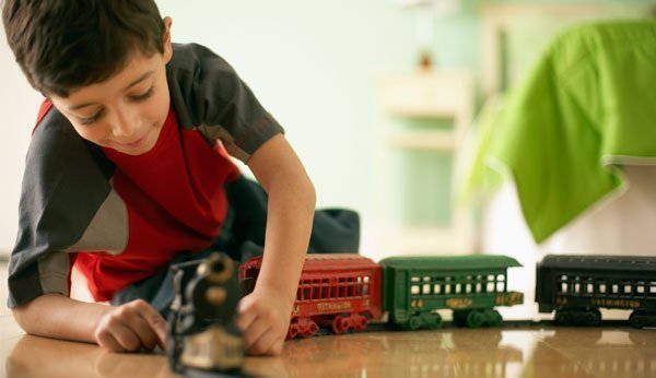 Kinderspielzeug: Junge spielt mit Eisenbahn