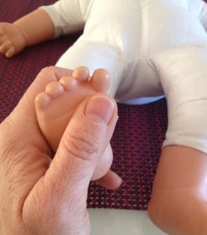 Instructions de massage pour bébé: bouger les orteils du pied.