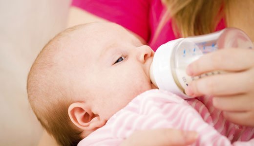 Ein Baby erhält Milch über den Schoppen.