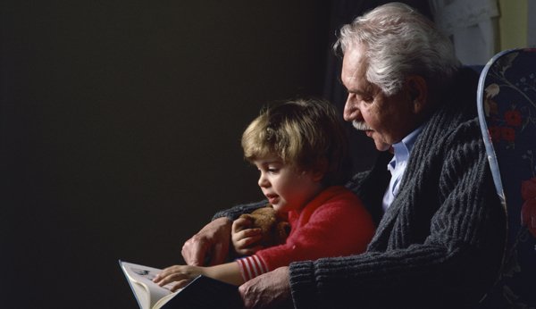 Grossvater liest mit Enkel