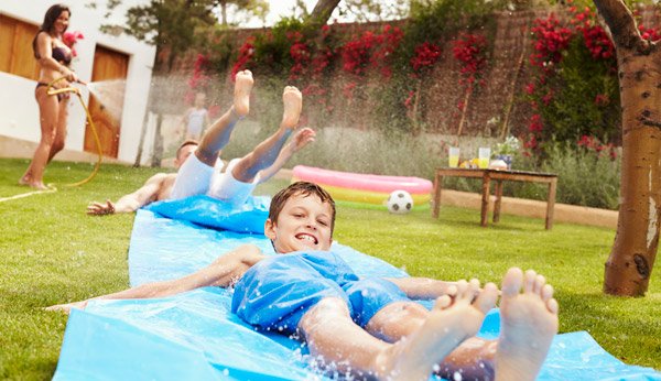 Kindergeburtstag feiern im Sommer: Spass auf der Wasserrutsche