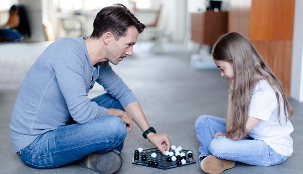 Gesellschaftsspiele für die ganze Familie: Ein Vater spielt mit seiner Tochter Abalone.