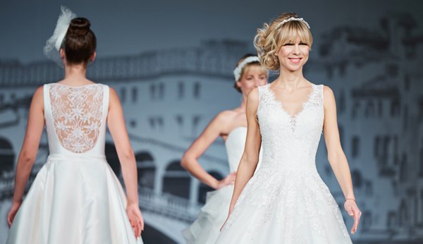Models führen an einer Hochzeitsmesse Brautkleidmodelle vor