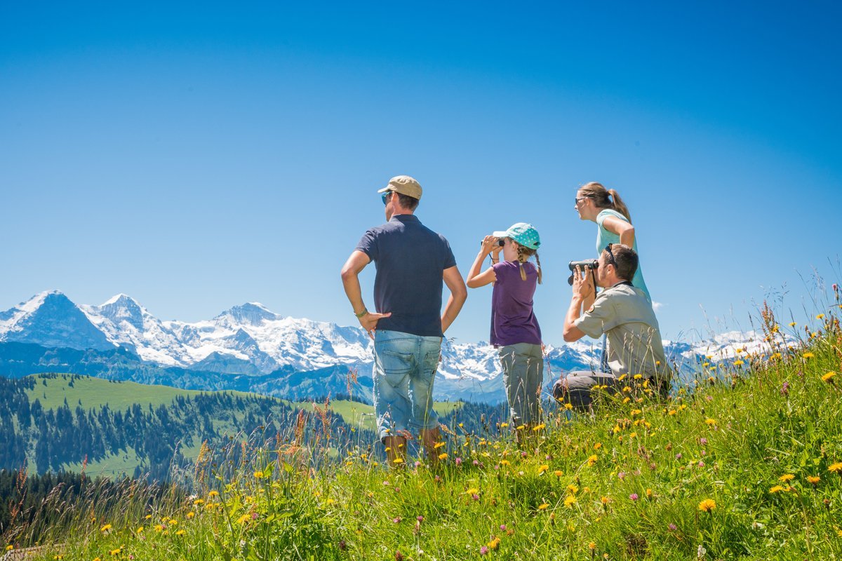 Eine Familie auf einem Hügelkamm betrachtet das Bergpanorama