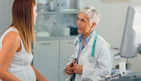 Amniocentèse: femme enceinte en discussion avec le gynécologue. 