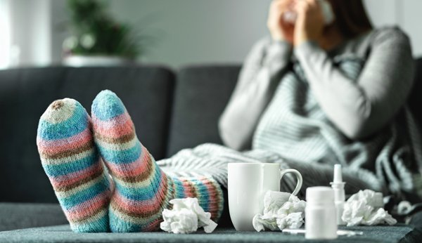 Grippe Eltern Schnupfen Frau auf dem Sofa mit Medizin