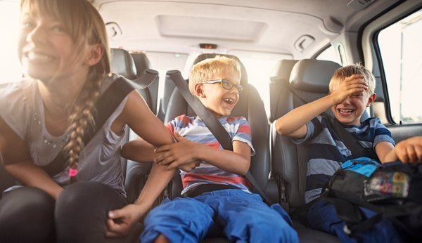 Conduire avec des enfants: Trois enfants dans la voiture, riant