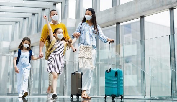 Une famille avec une protection bucco-nasale à l'aéroport