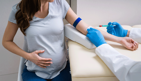 Test de sucre grossesse: un médecin prélève du sang sur une femme enceinte