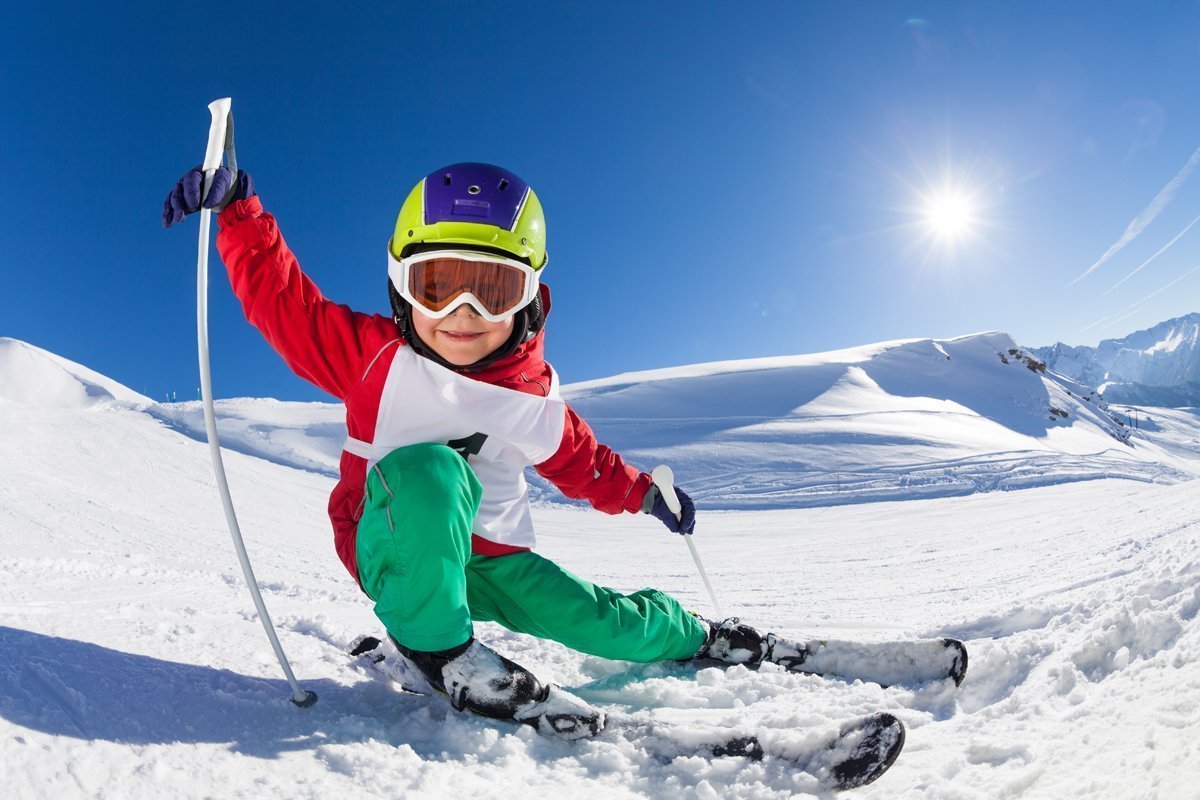 Kind steht auf Skiern und lernt Skifahren