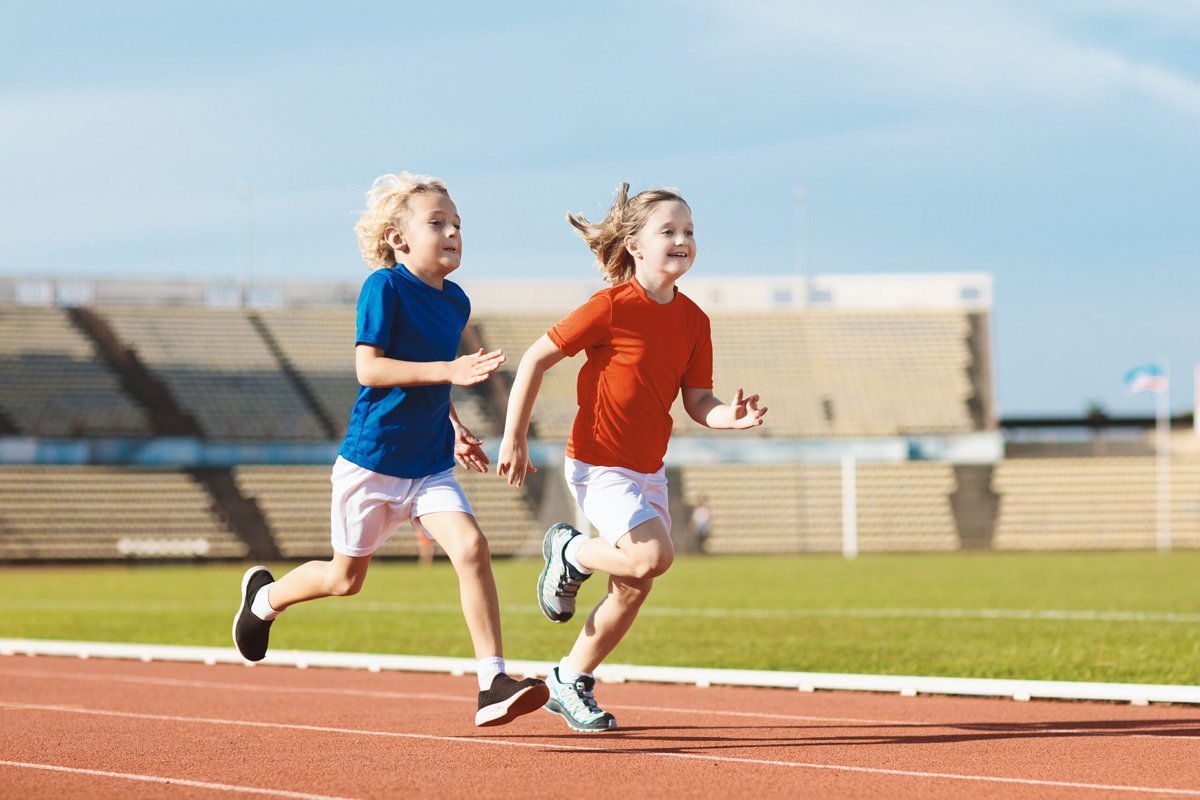Sportliche Kinder sprinten auf der Rennbahn
