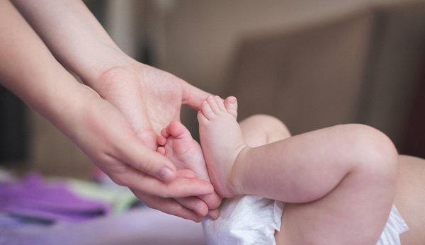 Constipação no bebé: a mãe embala o seu filho
