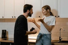 Ein Mann und eine Frau stehen in der Küche und streiten sich.