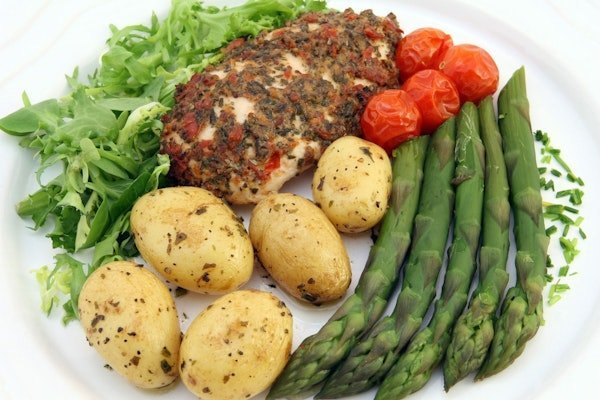 Teller mit Gemüse, Kartoffeln und Fleisch zur Veranschaulichung ausgewogener Ernährung