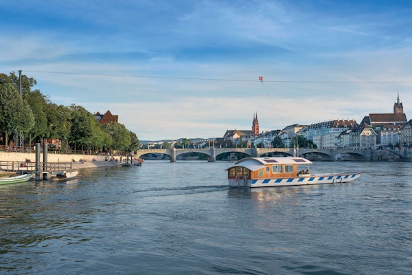Die Klingental-Fähre fährt über den Rhein. Im Hintergrund ist das Basler Münster, die Mittlere Brücke und die Kleinbasler Promenade.