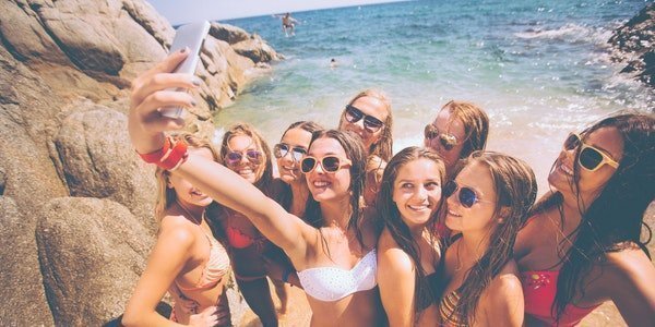 Gruppe junger Frauen am Strand macht ein Selfie