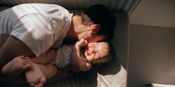Un père fait des câlins à son bébé.