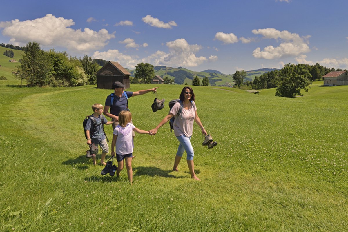 Eine Familie wandert barfuss durchs Appenzell.