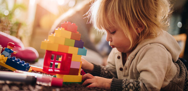 Bauen als Frühförderung: Ein Junge spielt mit Legos.