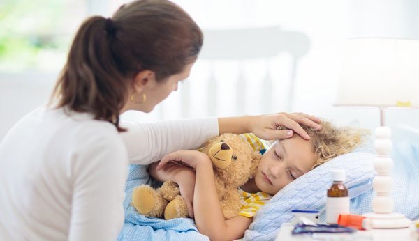 Forte fièvre chez un enfant: une mère s'occupe de son fils malade.