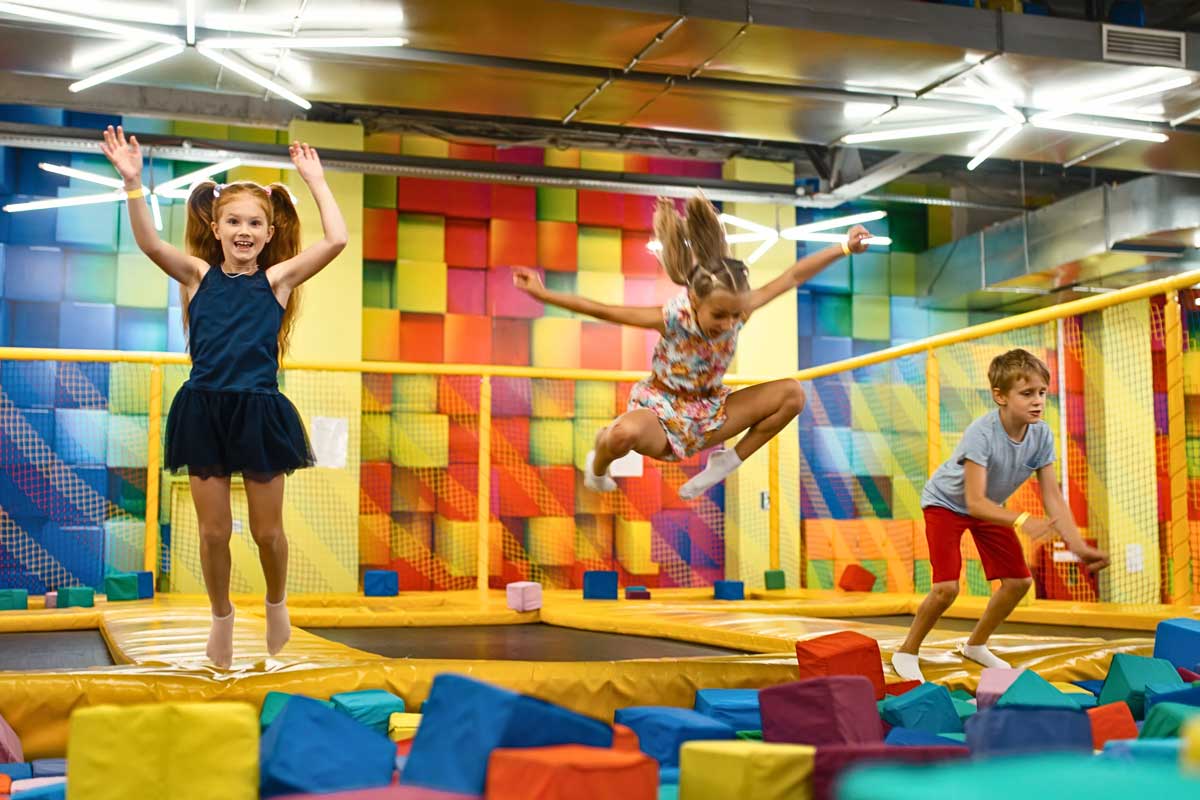 Kinder springen in einer Indoor Trampolinhalle.