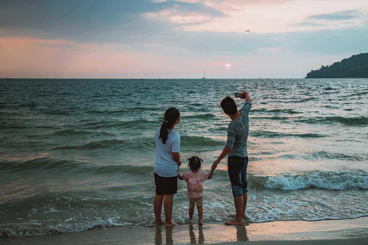 Eine Familie im Urlaub am Meer bei Sonnenuntergang