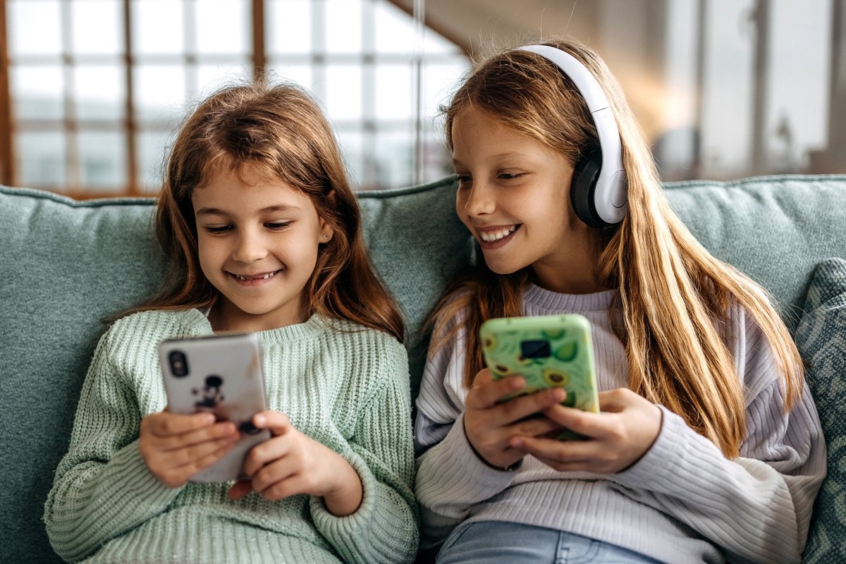 Zwei Kinder spielen zusammen mit dem Smartphone ihre Handy-Apps, die für ihr Alter geeignet sind.