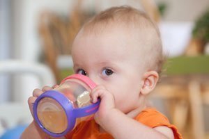 Ein Baby kann später aus einer Tasse selbst trinken.