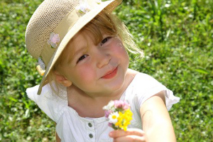 Kind pflückt Blumen im Feld