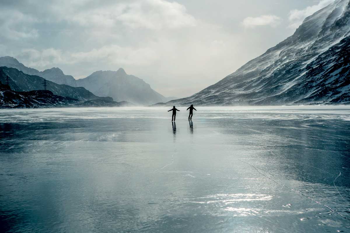 Kinder sind am Eiskunstlaufen auf dem Natureis des Lago Bianco in Poschiavo.